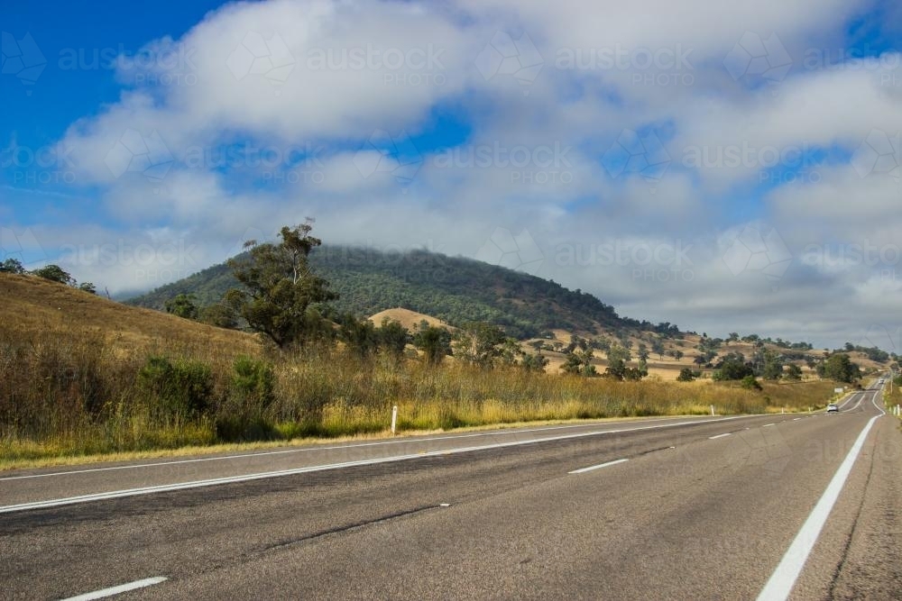 Low clouds on a mountain beside a highway - Australian Stock Image