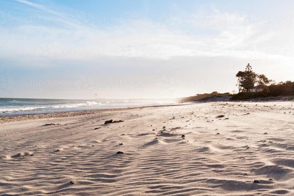Low down view of warm, wind rippled sand, spanning off into the distance of a long beach - Australian Stock Image