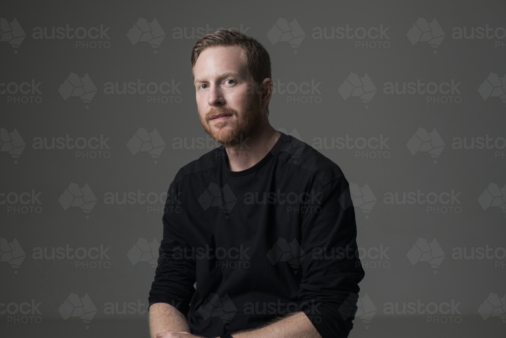 Low key portrait of young man in studio - Australian Stock Image