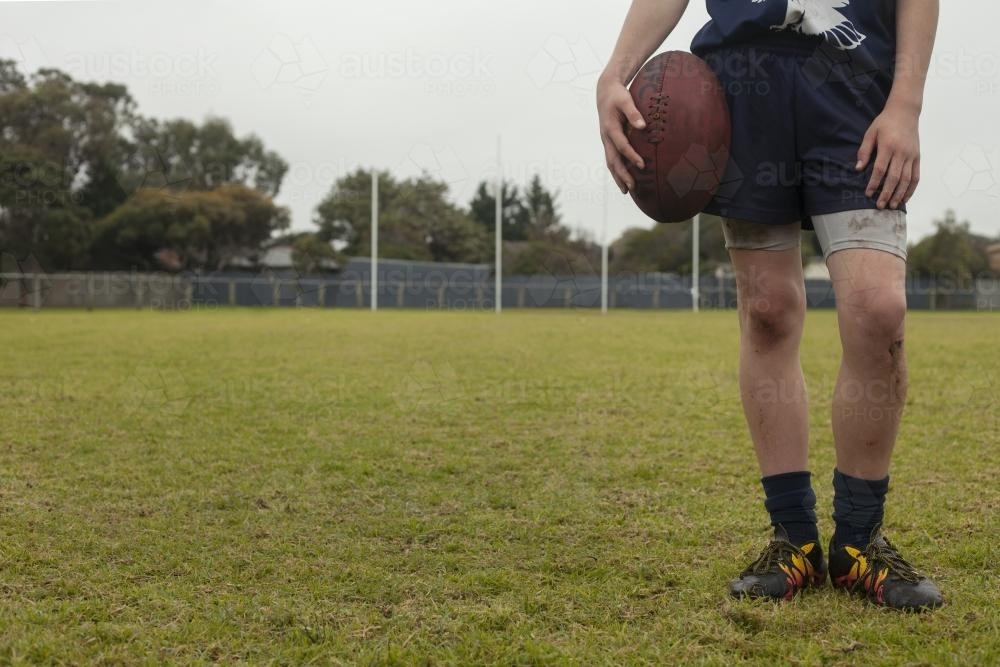 Low view of legs and torso of grassroots Footy player - Australian Stock Image