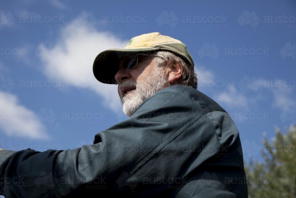Low view of middle aged male farmer outdoors on rural property - Australian Stock Image