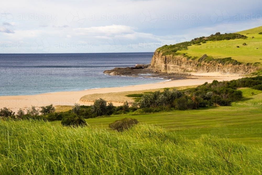 Lush green hills leading up to an isolated beach - Australian Stock Image