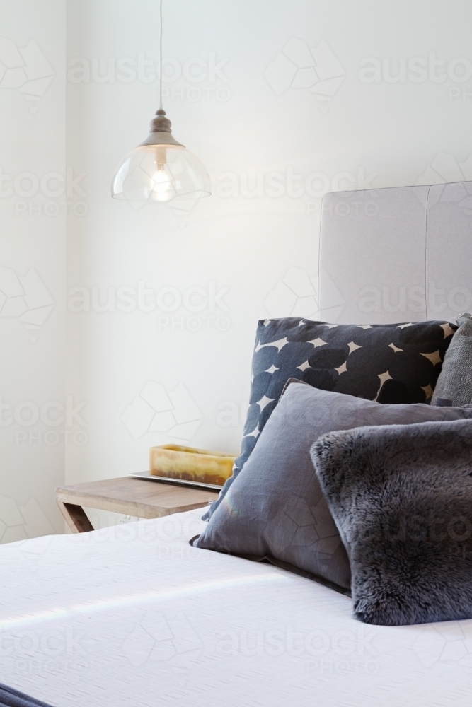 Luxury bedroom details throw pillows and bedside penant light - Australian Stock Image
