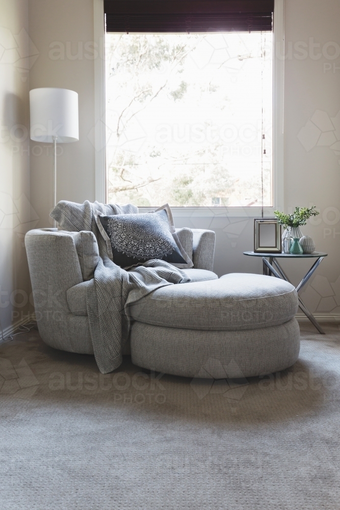 Luxury grey bedroom corner armchair under a window - Australian Stock Image