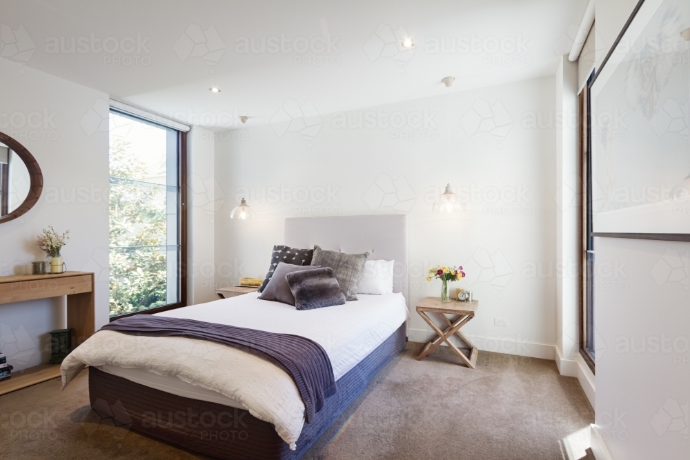 Luxury interior designed bedroom with comfy pillows and throw rug - Australian Stock Image