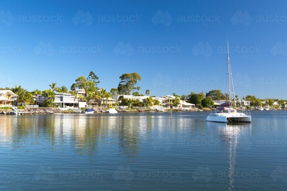 Luxury waterfront living with boat in foreground - Australian Stock Image