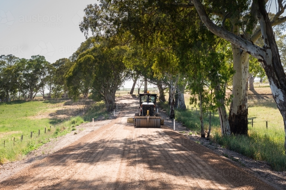 machine grading a dirt road in the country - Australian Stock Image