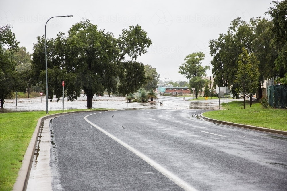 Main road leading to major river flooding in rural town - Australian Stock Image
