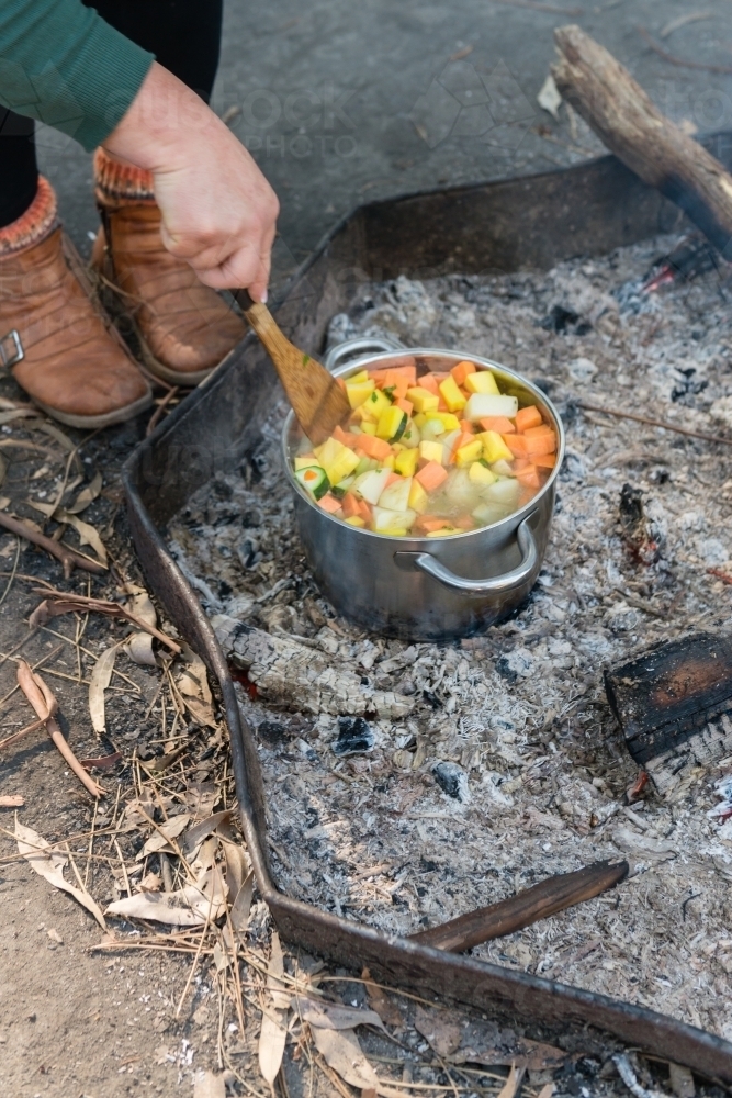 Making food on a campfire, vegetable soup in a saucepan - Australian Stock Image