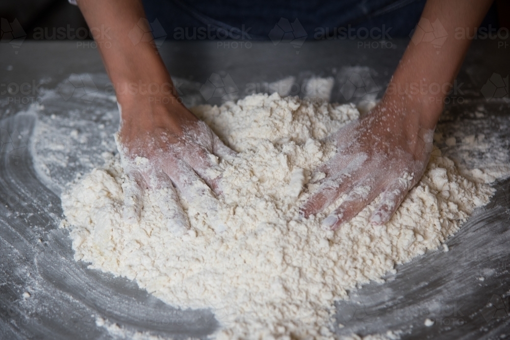 making gnocchi, close up of hands mixing the flour in preparation - Australian Stock Image