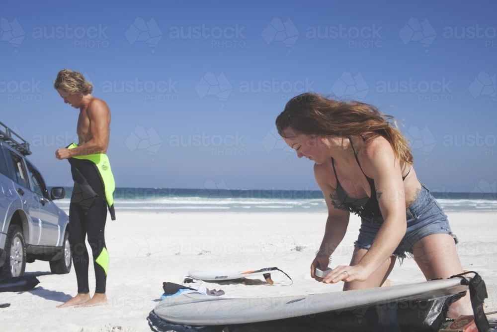 Male and Female friend prep for surf in Western Australia - Australian Stock Image