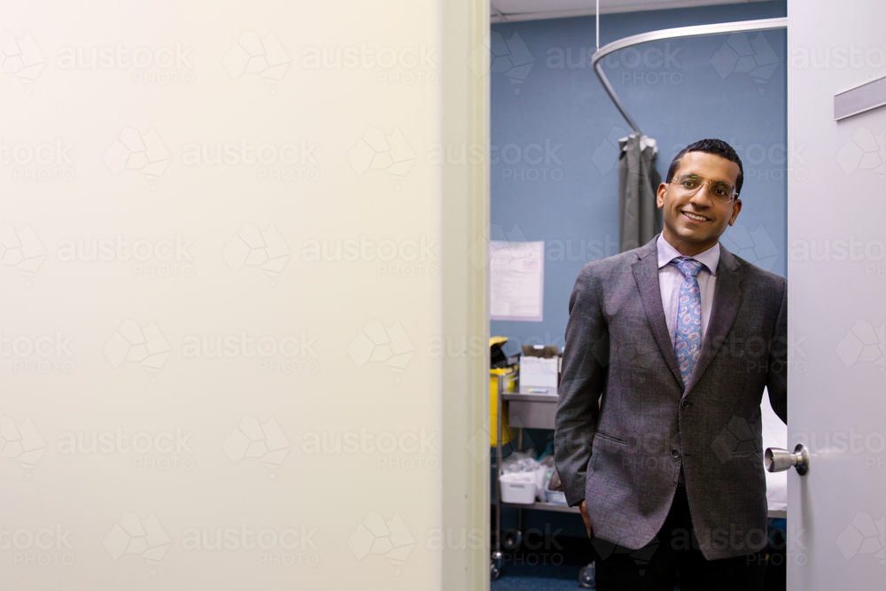 Male doctor opening clinic door - Australian Stock Image