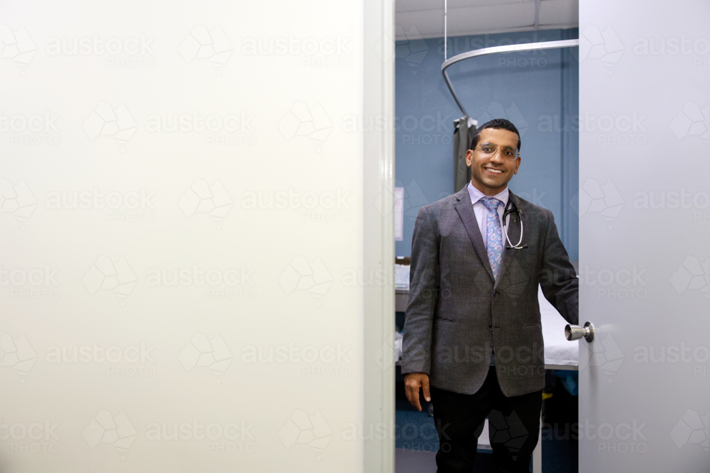 Male doctor opening clinic door - Australian Stock Image