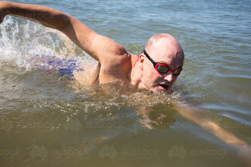 Male open water swimmer using freestyle - Australian Stock Image