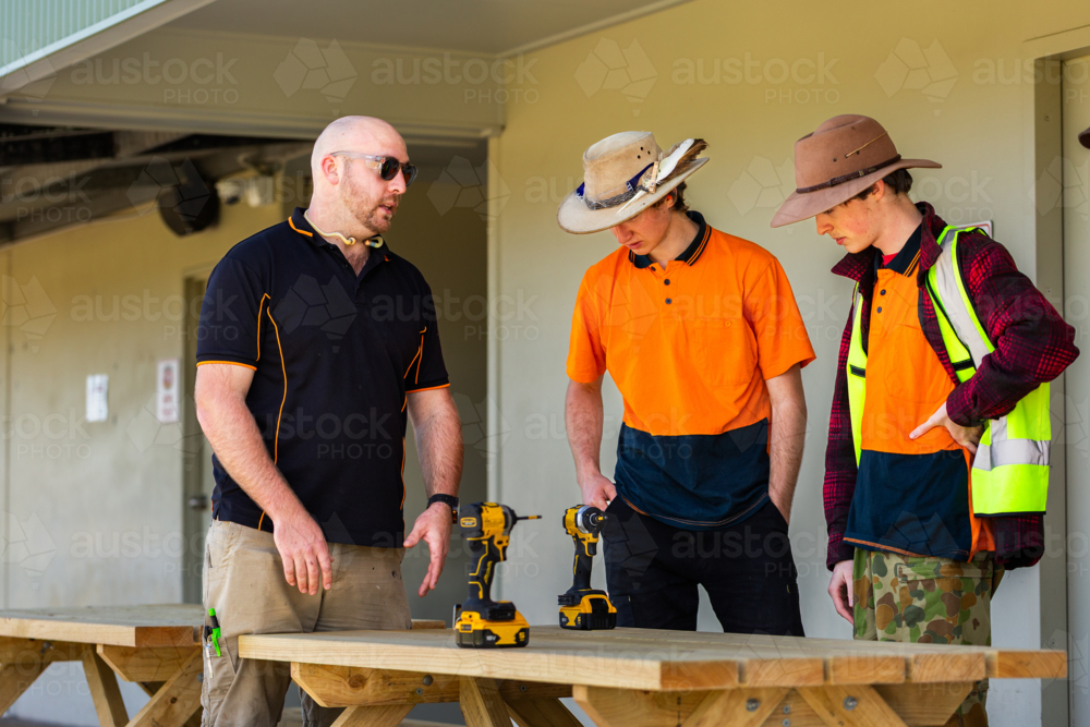 Image of male tradesman instructor talking with young trade apprentice ...