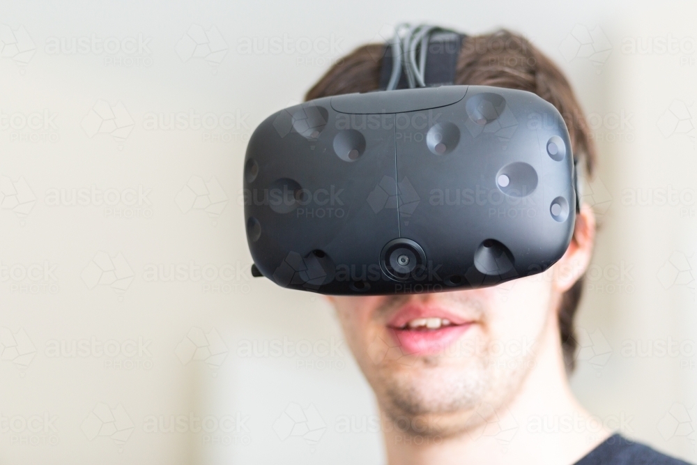 Male wearing VR headset to see into virtual reality - Australian Stock Image