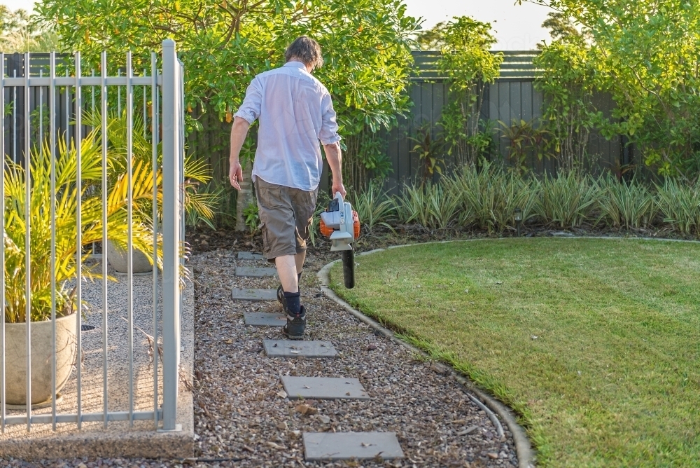 Male with blower in home garden - Australian Stock Image
