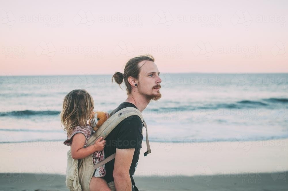 Man and child, baby wearing at the beach - Australian Stock Image