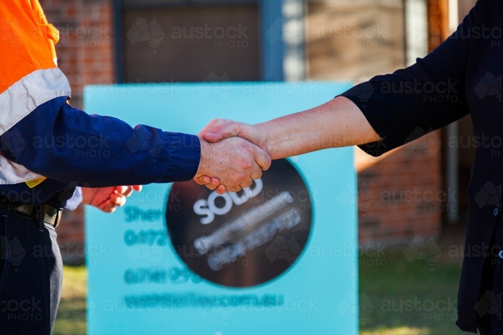 Man and real estate agent shake hands over house purchase - Australian Stock Image