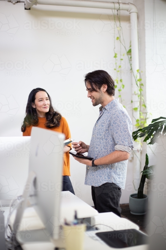 Man and woman chatting in an office - Australian Stock Image