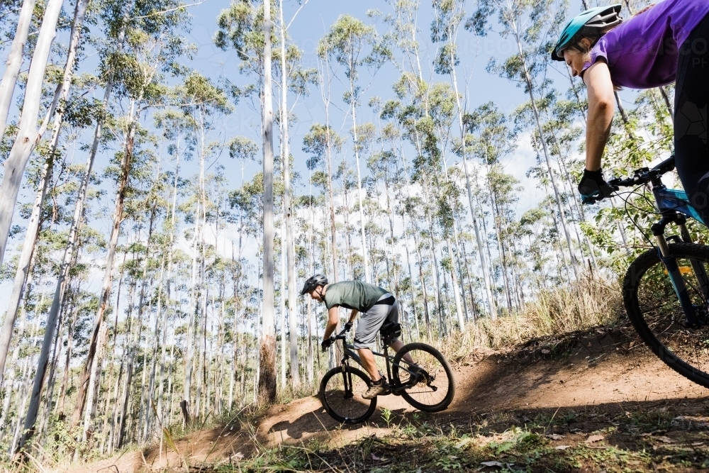 man and woman cyclist riding their bicycle on a mountain bike trail - Australian Stock Image