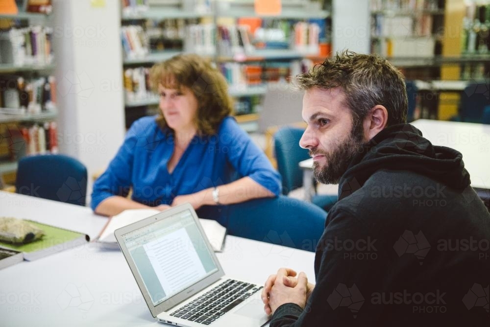 Man and woman studying in the university library - Australian Stock Image