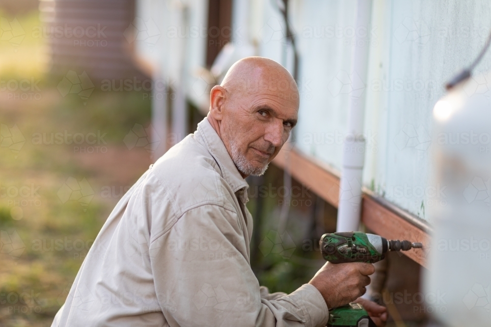 man doing maintenance with cordless drill - Australian Stock Image