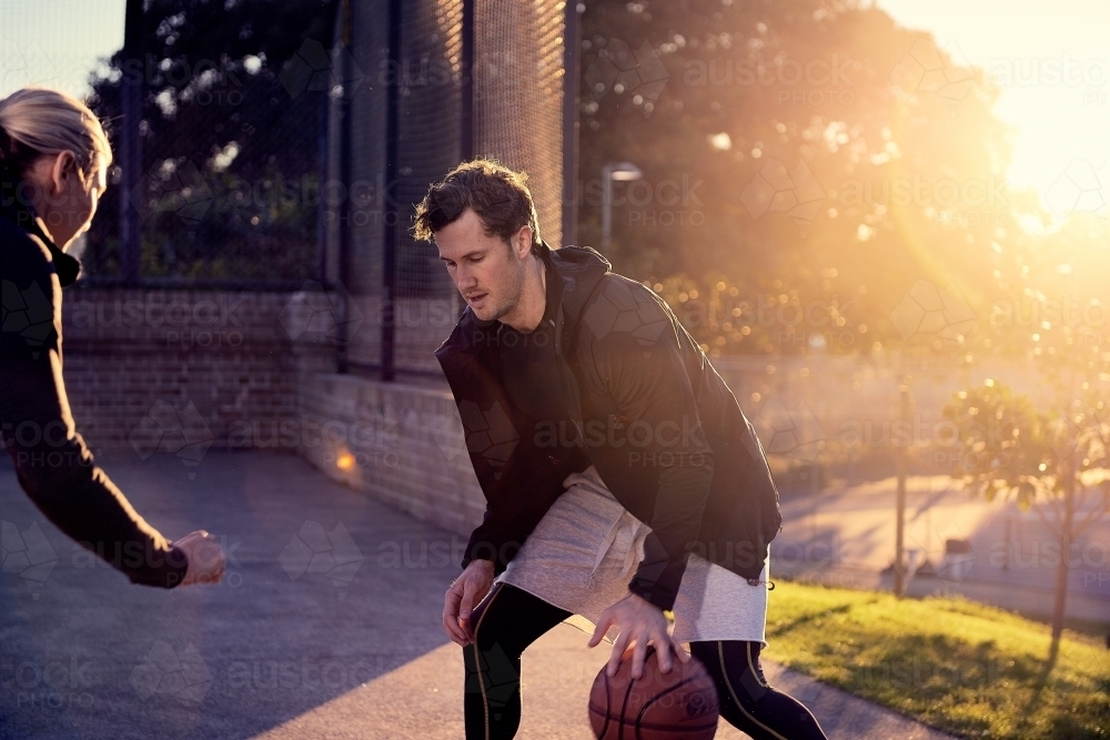 Man dribbling basketball in one on one game - Australian Stock Image