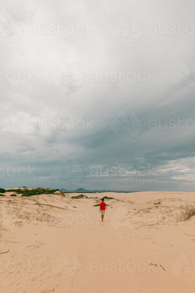 Man exploring sand dunes at Mungo Beach on the NSW coast - Australian Stock Image