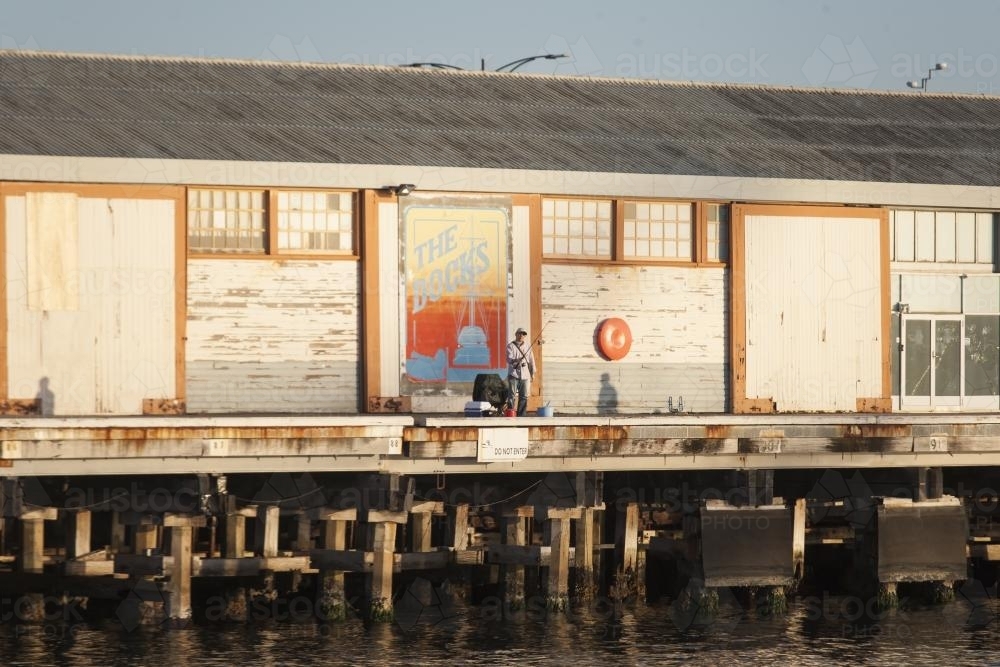 Man fishing from a pier at Fremantle Ports - Australian Stock Image