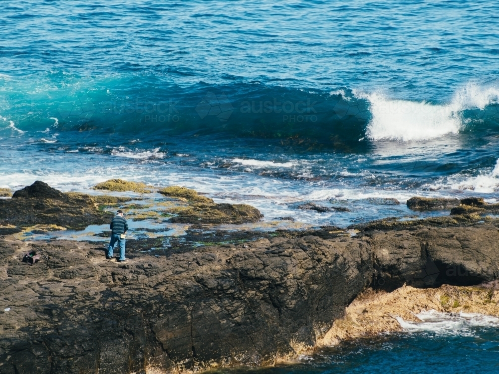Man fishing on the rocks - Australian Stock Image
