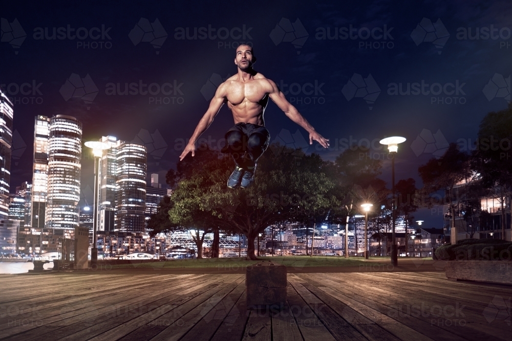 Man fitness training in urban area at night - Australian Stock Image
