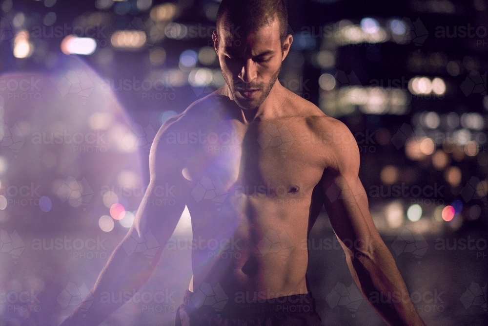 Man fitness training in urban area at night - Australian Stock Image