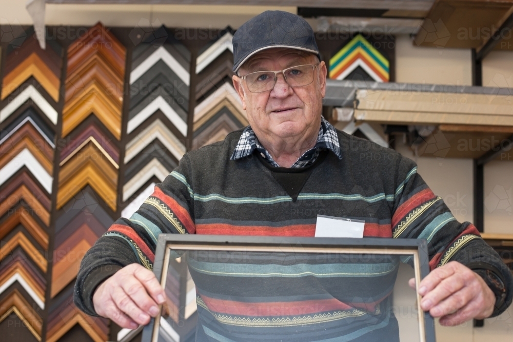 Man framing a picture at a men's shed - Australian Stock Image