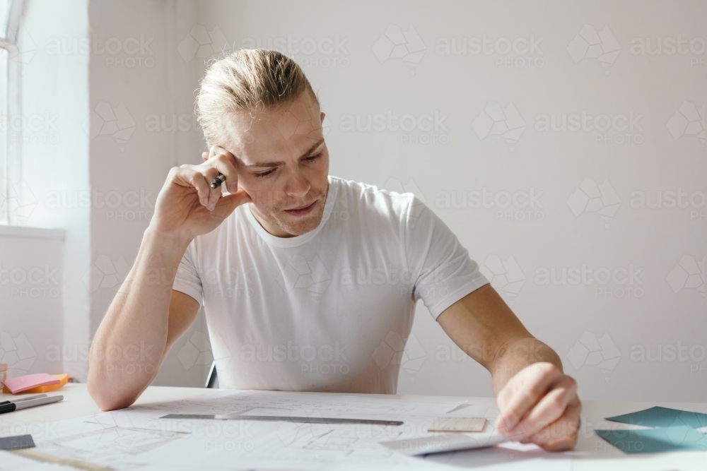 Man frowning and deep in thought at work - Australian Stock Image