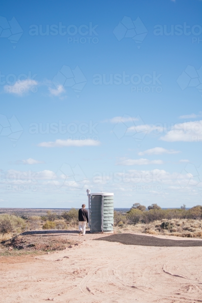 Man going to roadside toilet - Australian Stock Image