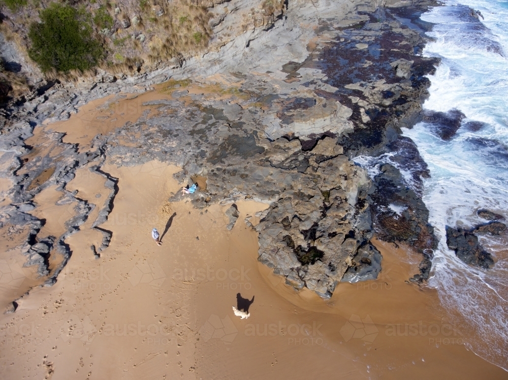 Man, Golden Retriever and Woman on a Beach Photographed from Above - Australian Stock Image