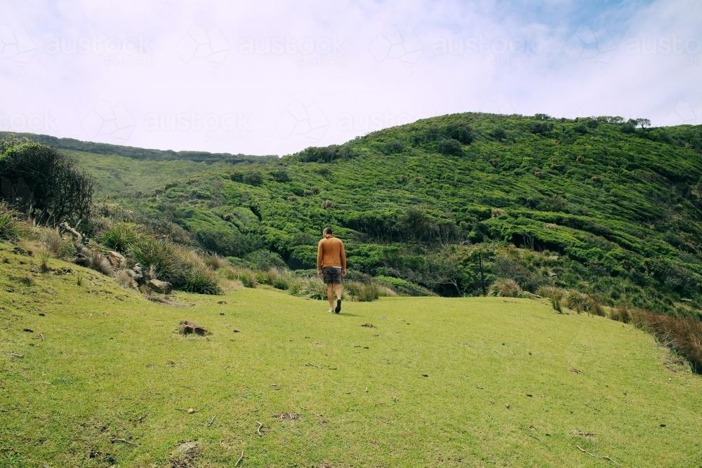 Man Hiking on Grassy Slope - Australian Stock Image