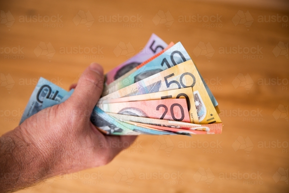 man holding a bunch of Australian currency - Australian Stock Image