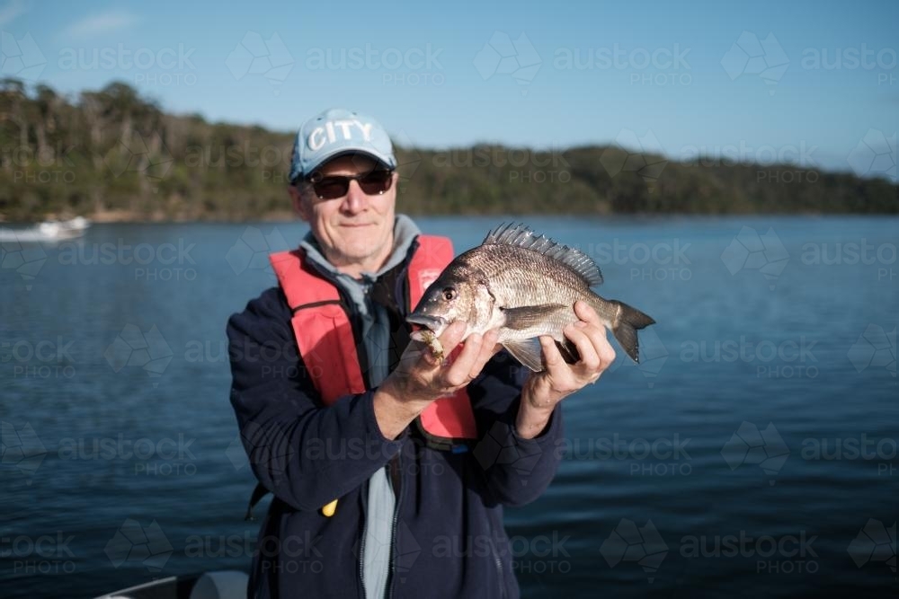 Man holding a Southern Black Bream he Caught - Australian Stock Image