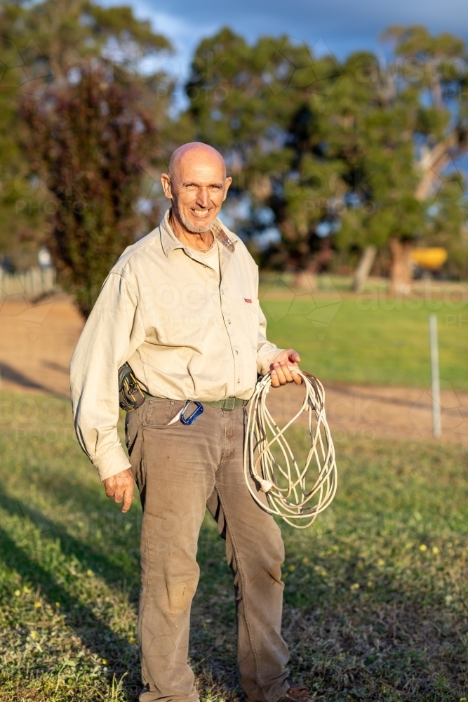 man holding electrical extension cord like a lasso - Australian Stock Image