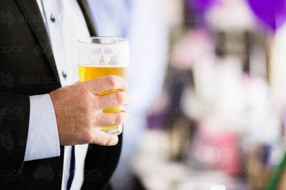 Man holding glass of beer in club - Australian Stock Image