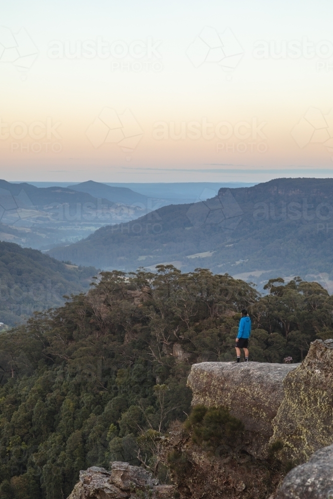 Man in distance overlooking mountains - Australian Stock Image
