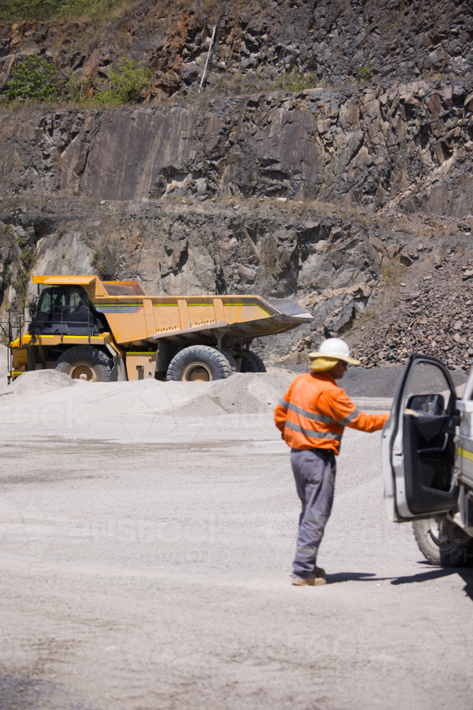 Man in high visibility clothing opening the door of his car. - Australian Stock Image