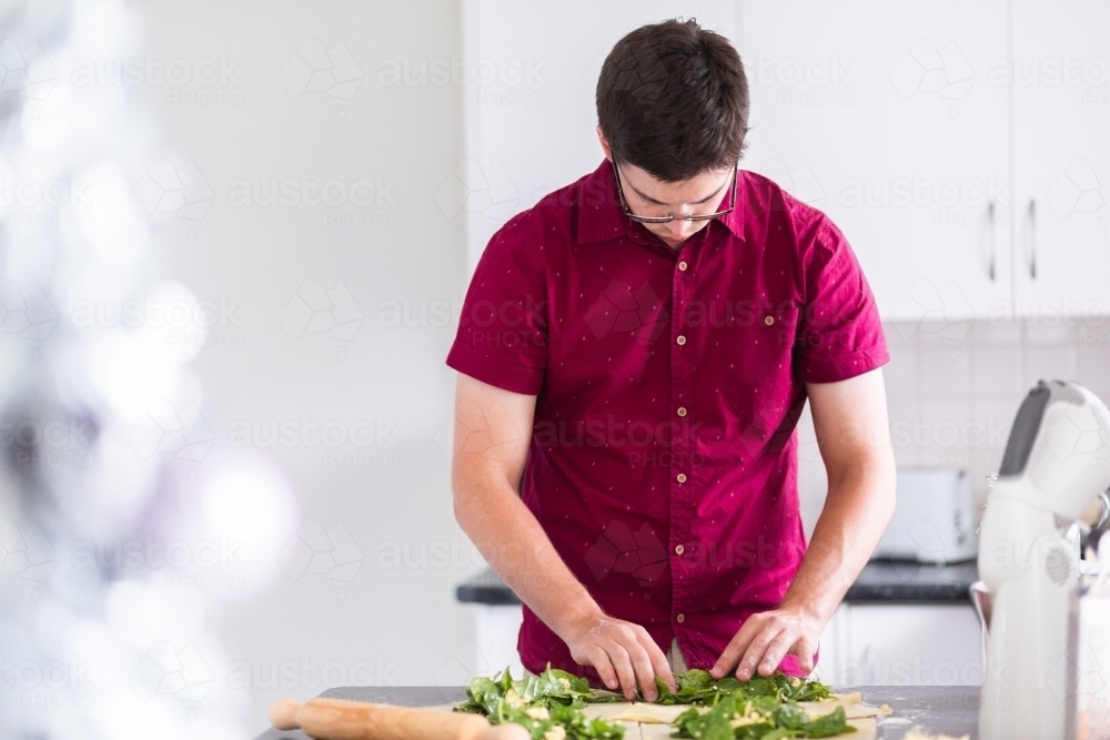 Man in kitchen making homemade gozleme - Turkish stuffed flatbread - Australian Stock Image