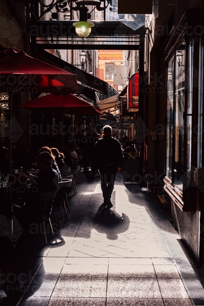 Man in shadow walking down melbourne coffee laneways - Australian Stock Image