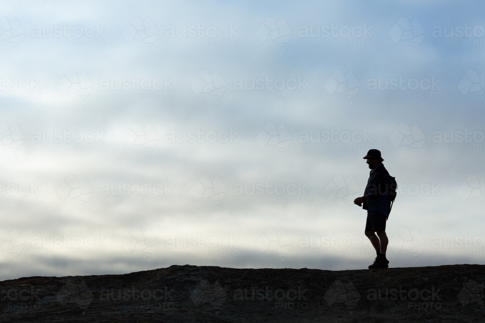 Man in silhouette against cloudy overcast sky - Australian Stock Image