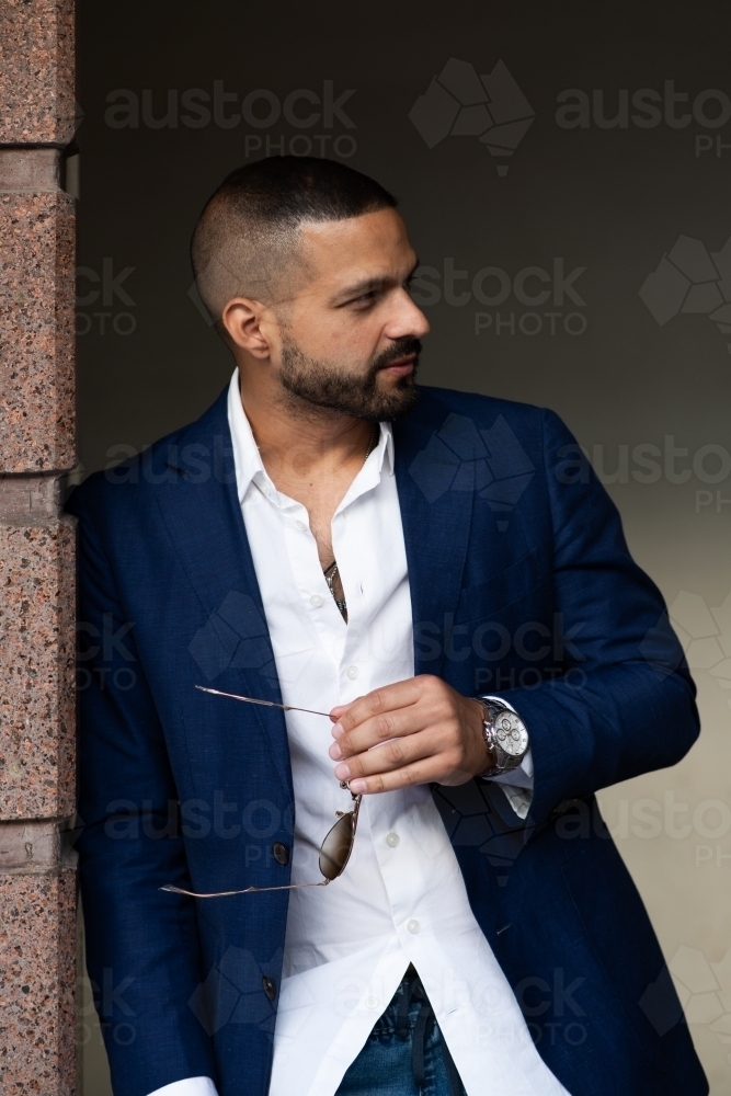 man in suit, holding sunglasses - Australian Stock Image