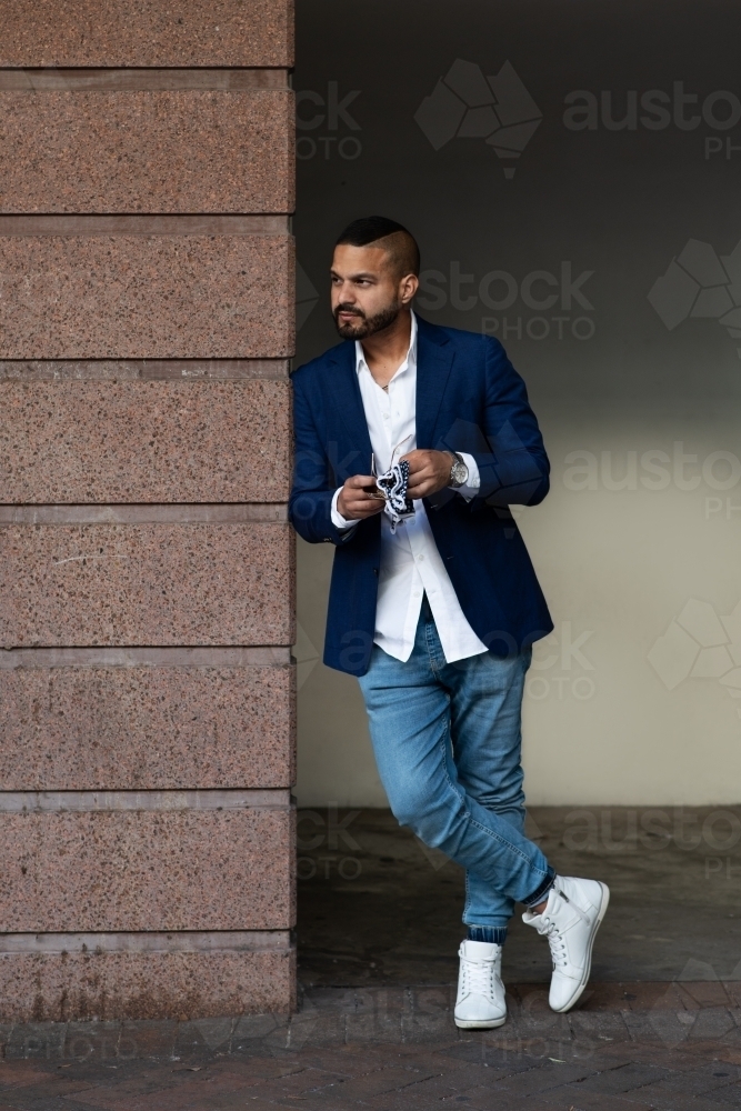 man in suit jacket with jeans and sneakers - Australian Stock Image