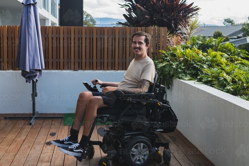 man in wheelchair on outdoor patio - Australian Stock Image